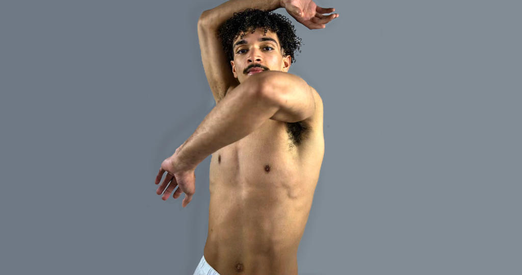 Dance alum Michael Cherry in a pose against a gray background